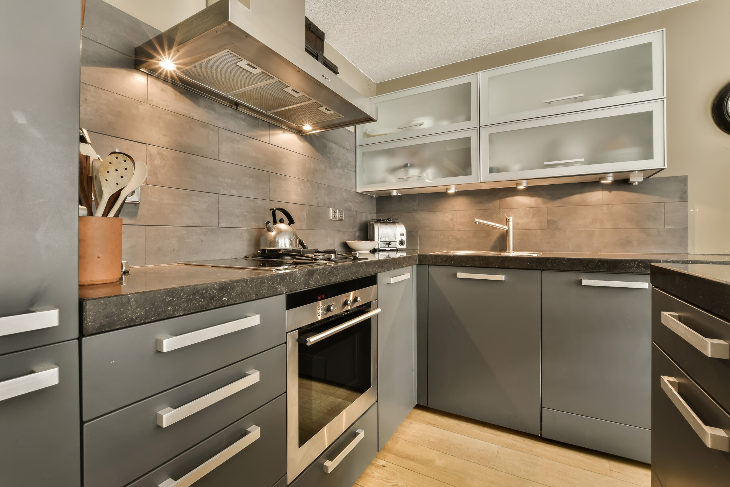a kitchen with gray cabinets and stainless steel appliances